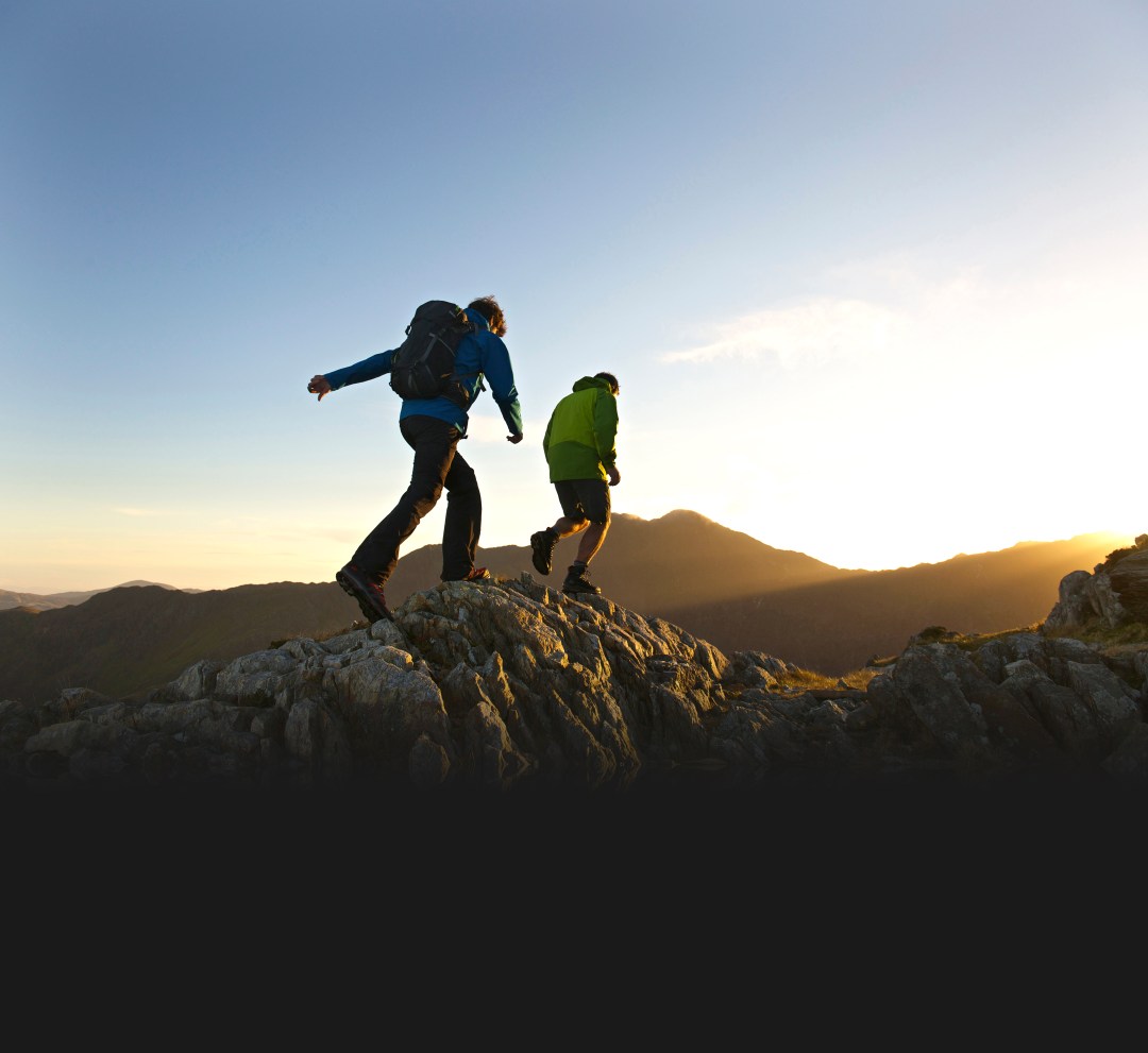 Two men walking over a rocky outcrop during the winter months