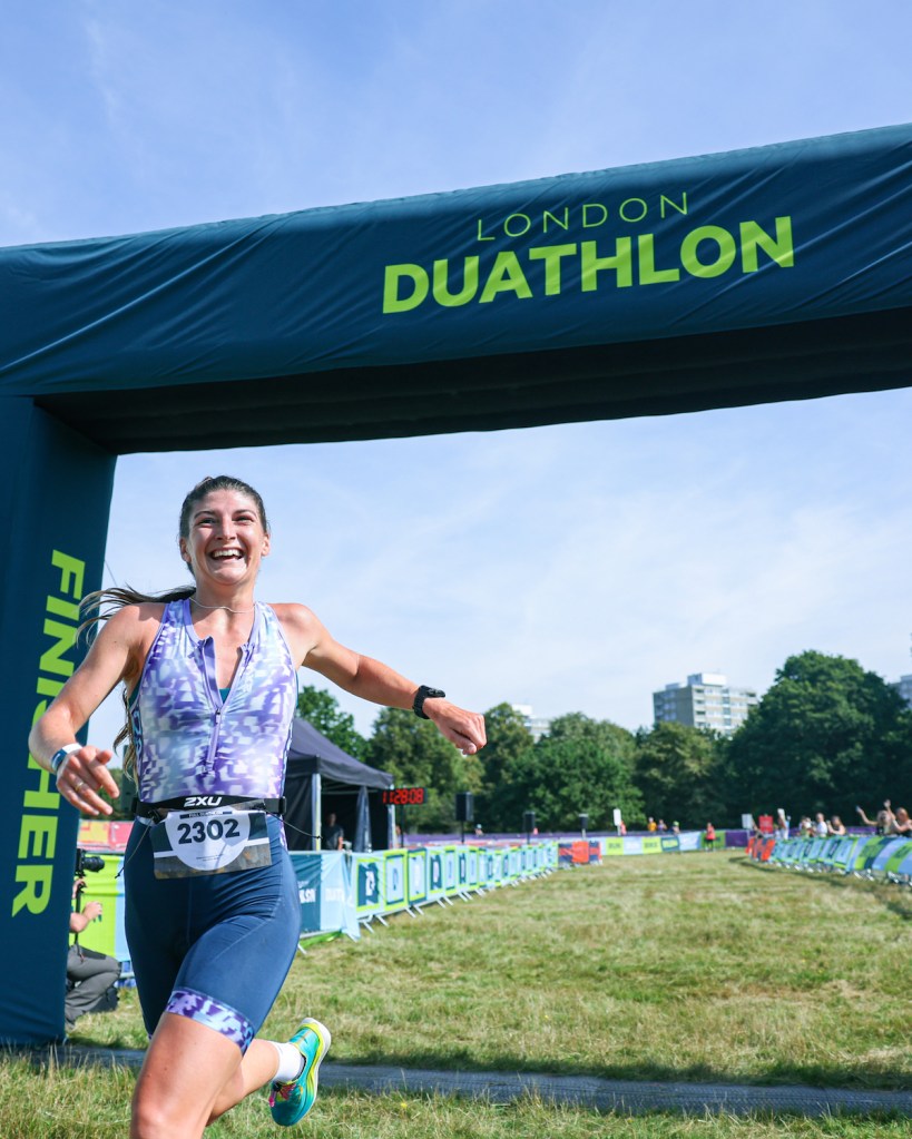 Female runner crossing the line of London duathlon