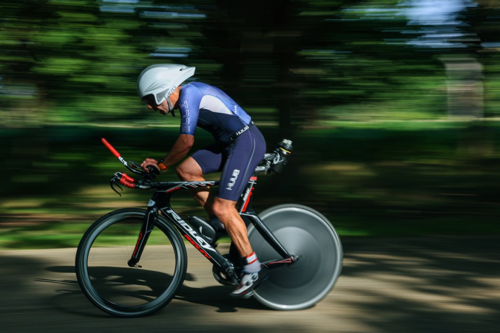 Athelte cycling in London Duathlon wearing a tri-suit and aero helmet