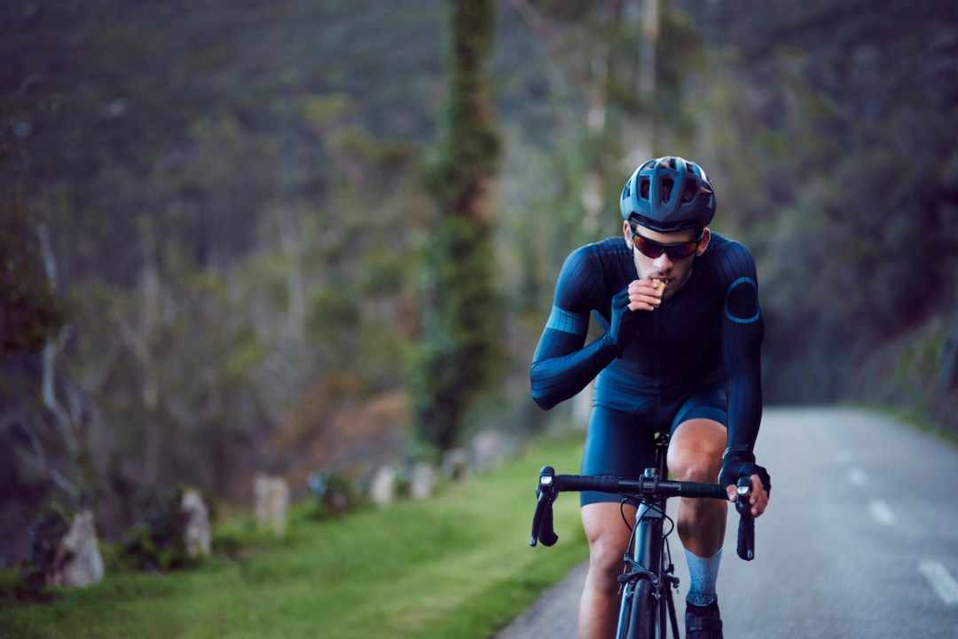 Male cyclist eating while riding