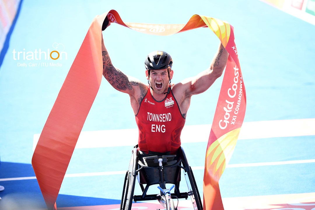 Joe Townsend holds the winner's tape above his head in triumph as he crosses the line to win gold