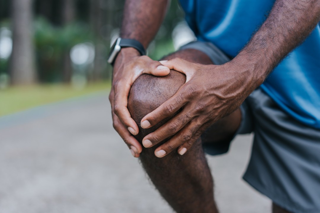 Close up of a male runner's hands over his knee