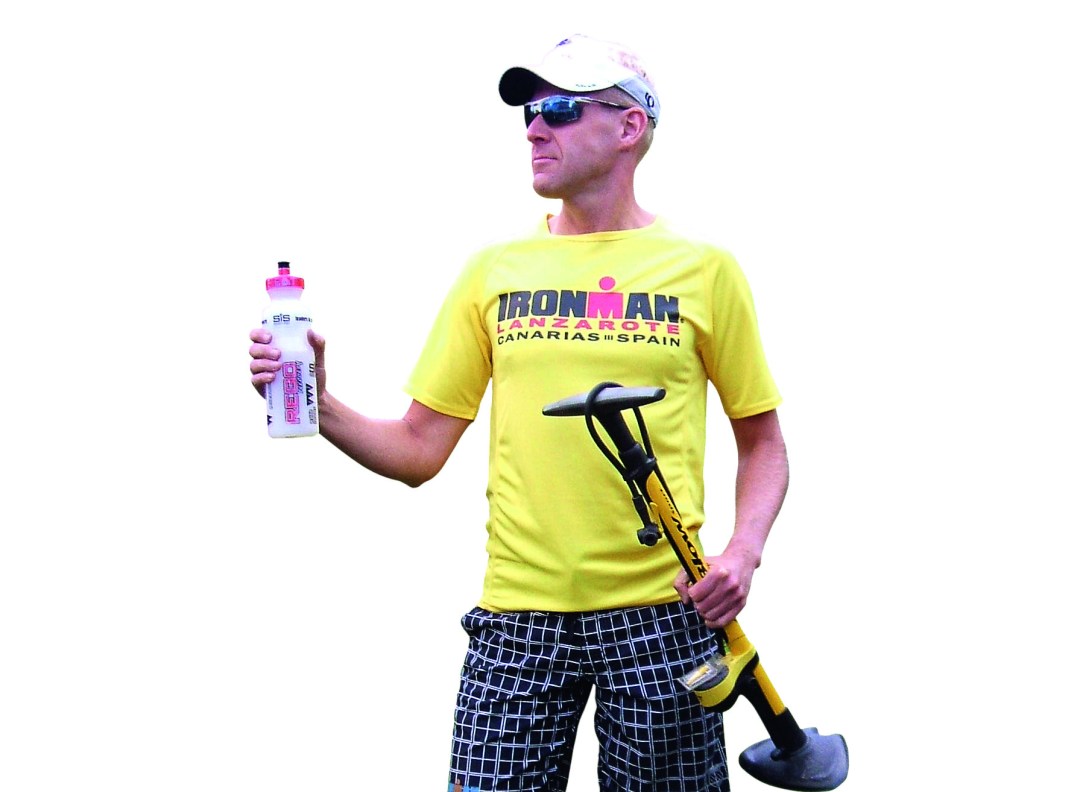 Martyn Brunt wearing an Ironman Lanzarote T-shirt while holding a water bottle and a bike pump
