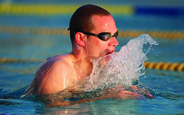 Man swimming breaststroke in pool