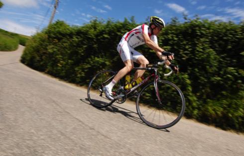 Male cyclist descending a hill on a road bike