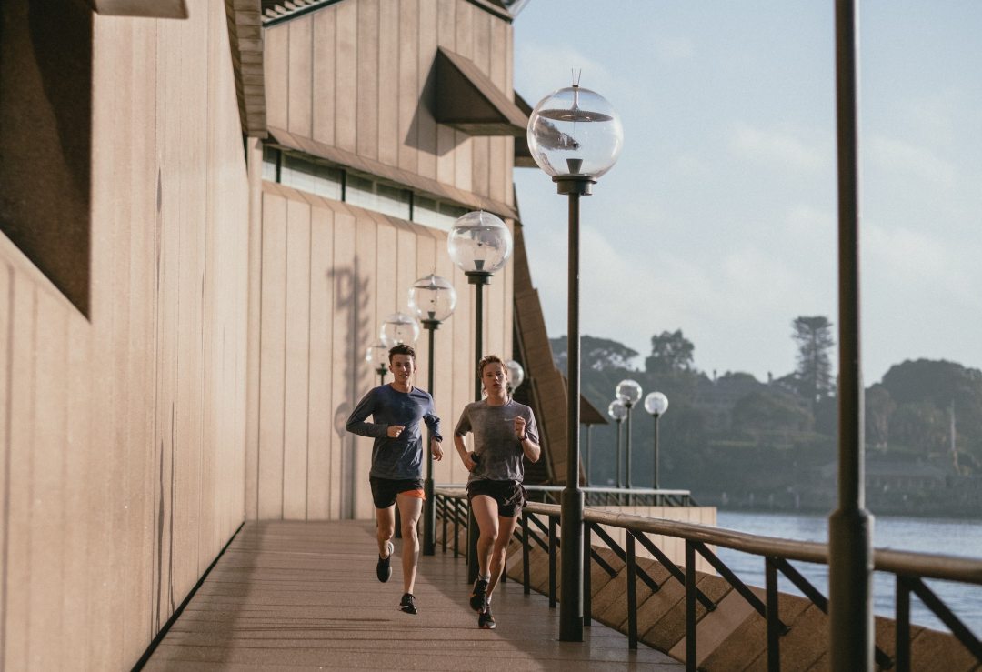 Two men running by the coast