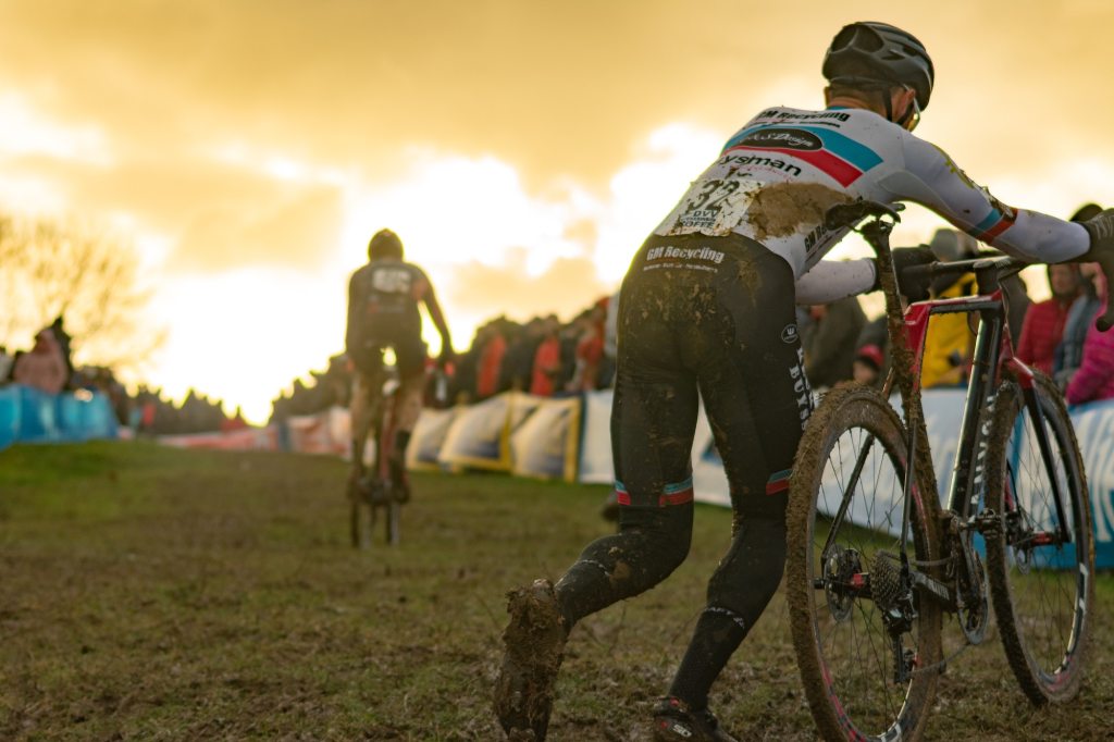 Cyclist pushing bike in cyclocross race