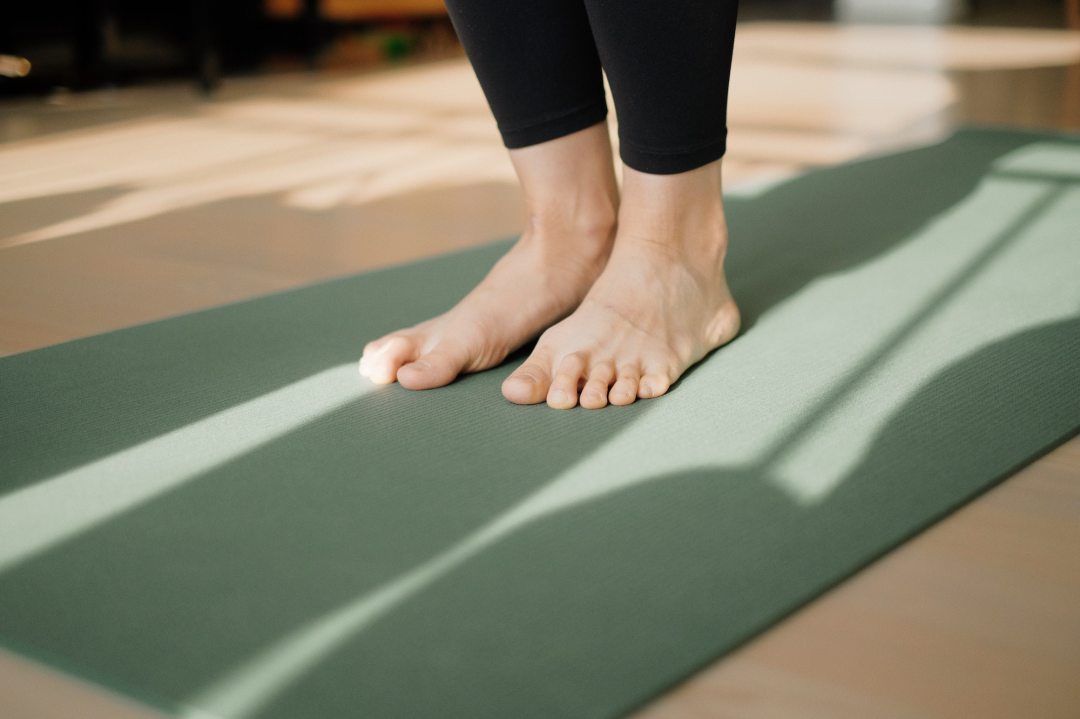 Person's feet on a yoga mat