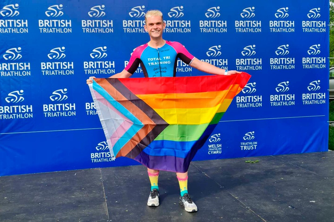 Jack Bristow holding up a rainbow flag