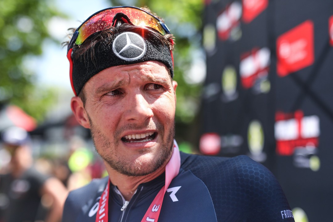 Jan Frodeno stands at the finish line of a triathlon