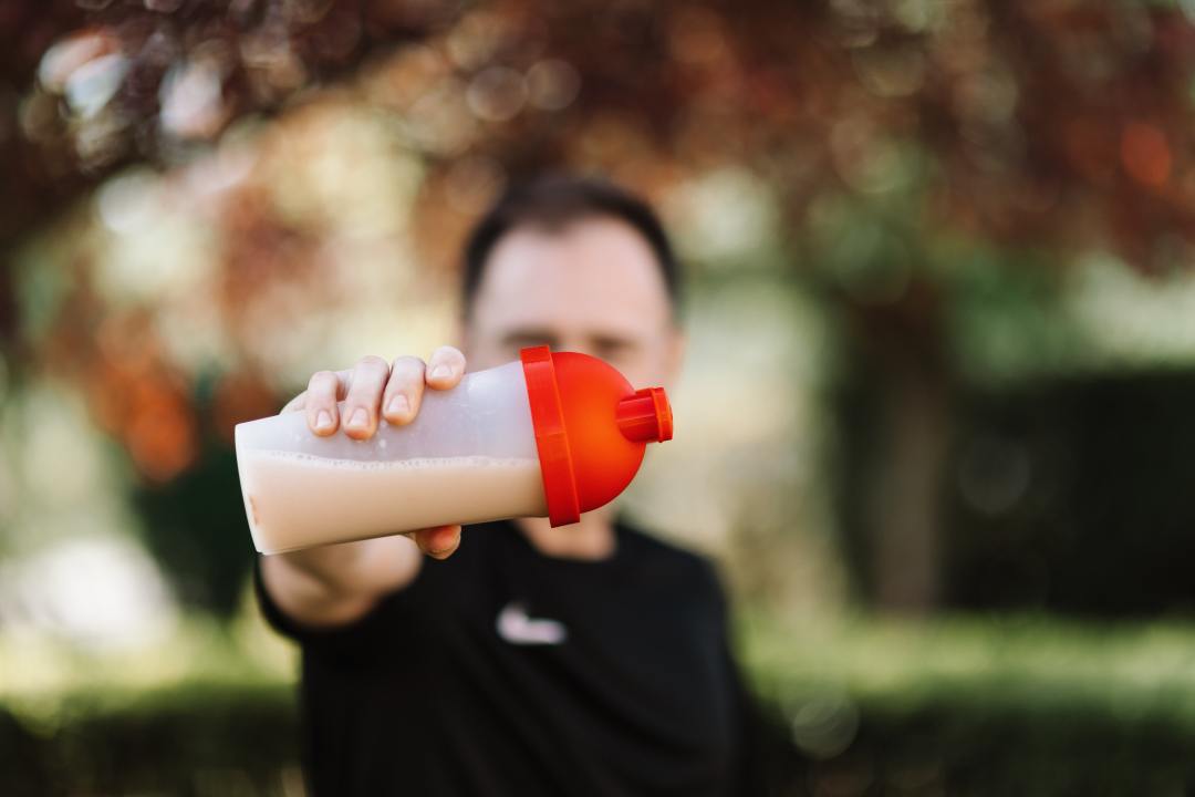 Man holding protein powder drink in bottle