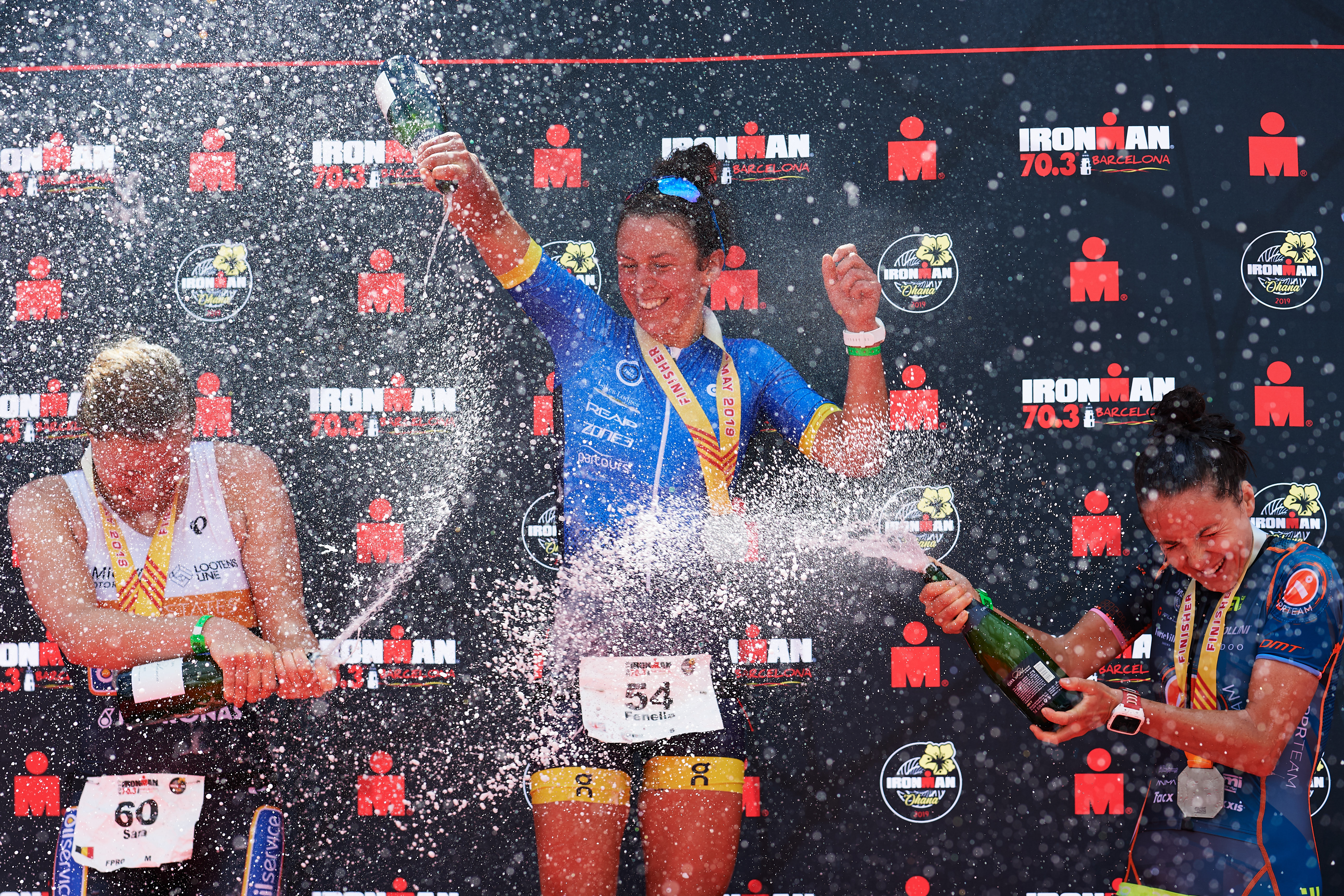 CALELLA, SPAIN - MAY 19: Fenella Langridge (C) of Great Britain in 1st place, Sara Van De Vel (L) of Belgium in 2nd place and Gabriella Zelinka (R) of Hungary in 3rd place celebrate their results after finishing IRONMAN 70.3 Barcelona on May 19, 2019 in Calella, Spain. (Photo by Alex Caparros/Getty Images for IRONMAN)