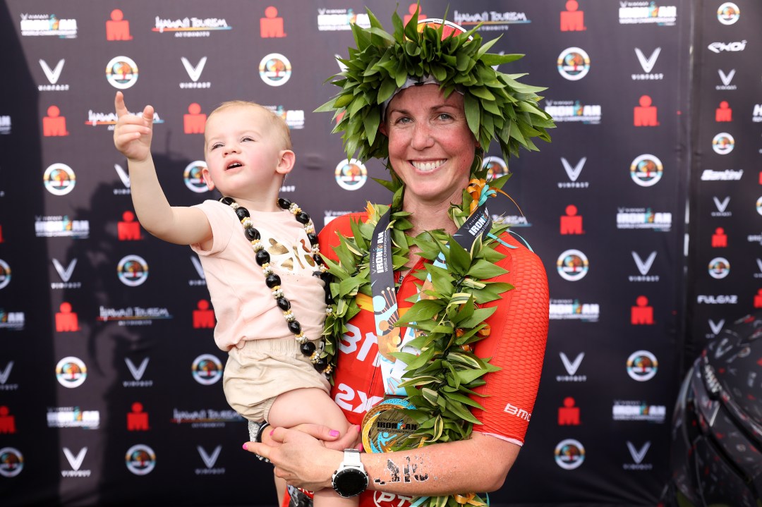 Chelsea Sodaro celebrates with her daughter Skylar after winning the Ironman World Championships on October 06, 2022 in Kailua Kona, Hawaii.