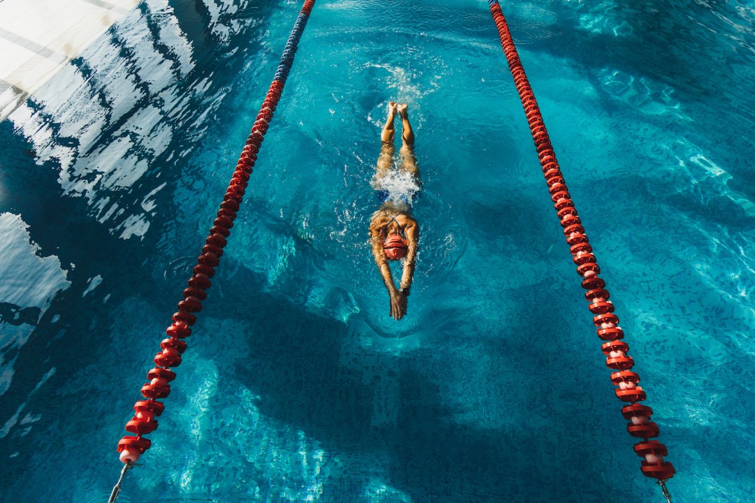 View from above of woman swimming by track in the pool
