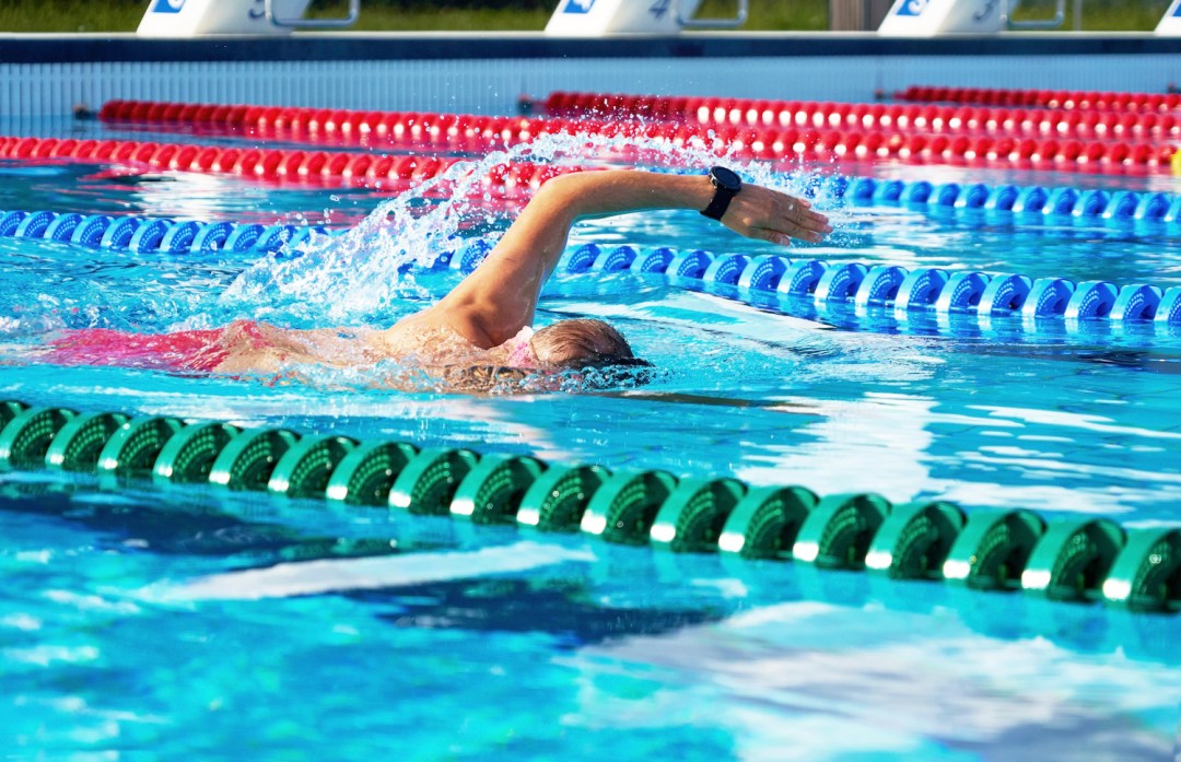Young man swimming front crawl in a pool