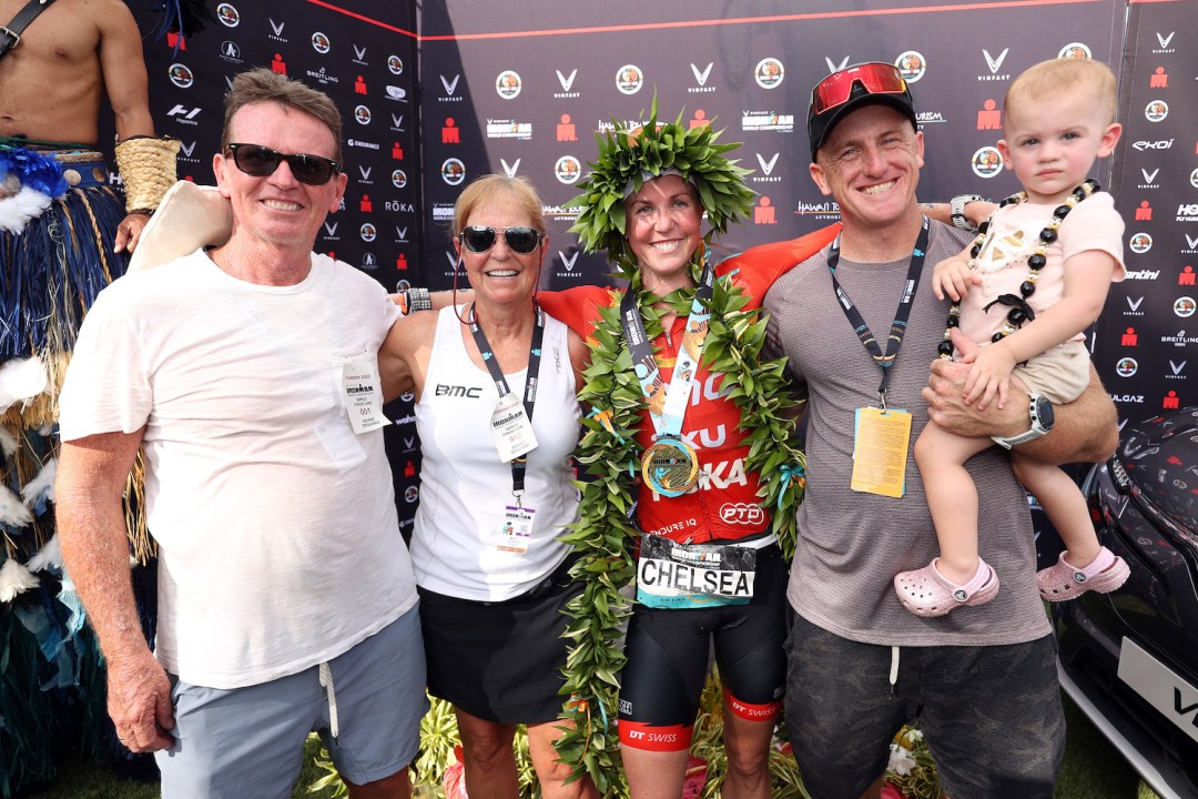 Chelsea Sodaro (C) poses with her father Peter Reilly, mother Marci Snodgrass, husband Steve Sodaro and daughter Skylar after winning the 2022 Ironman World Championship in Kailua Kona, Hawaii