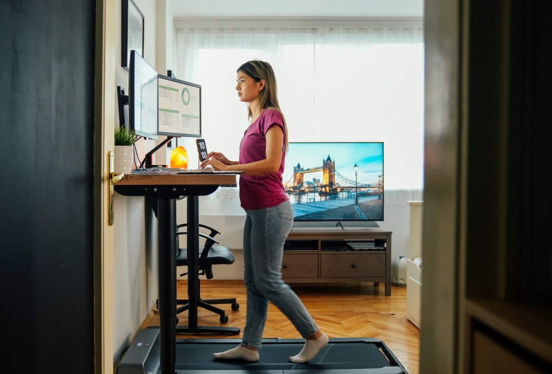 Woman walking on an under desk treadmill