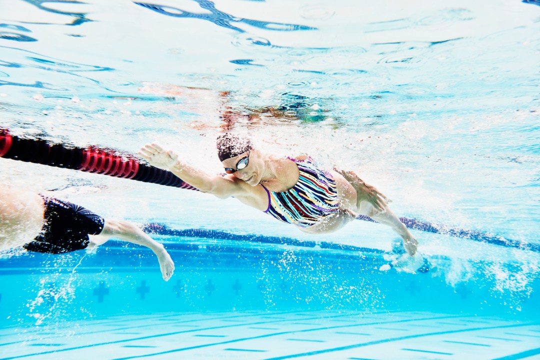 Underwater view of mature female athlete swimming during workout