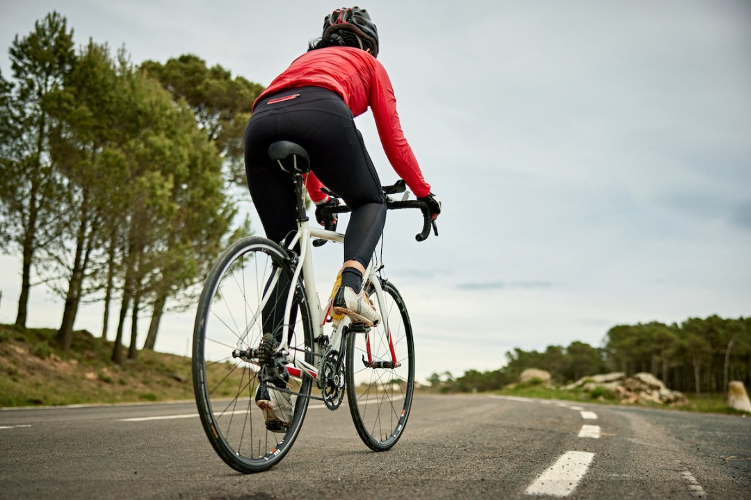 Woman cycling uphill on slight incline