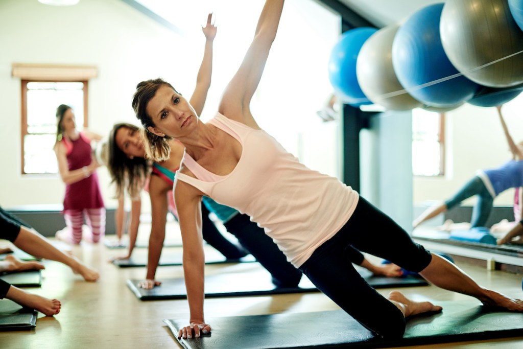 A group of women doing the side plank workout in a pilates class