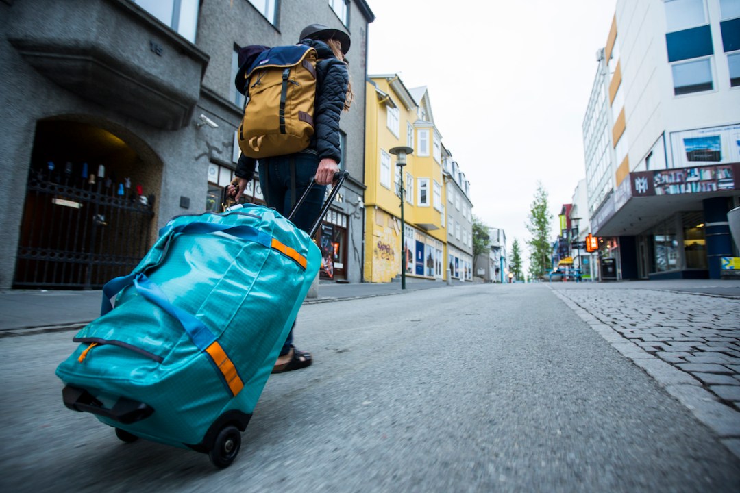 Woman pulling along a wheeled duffel bag