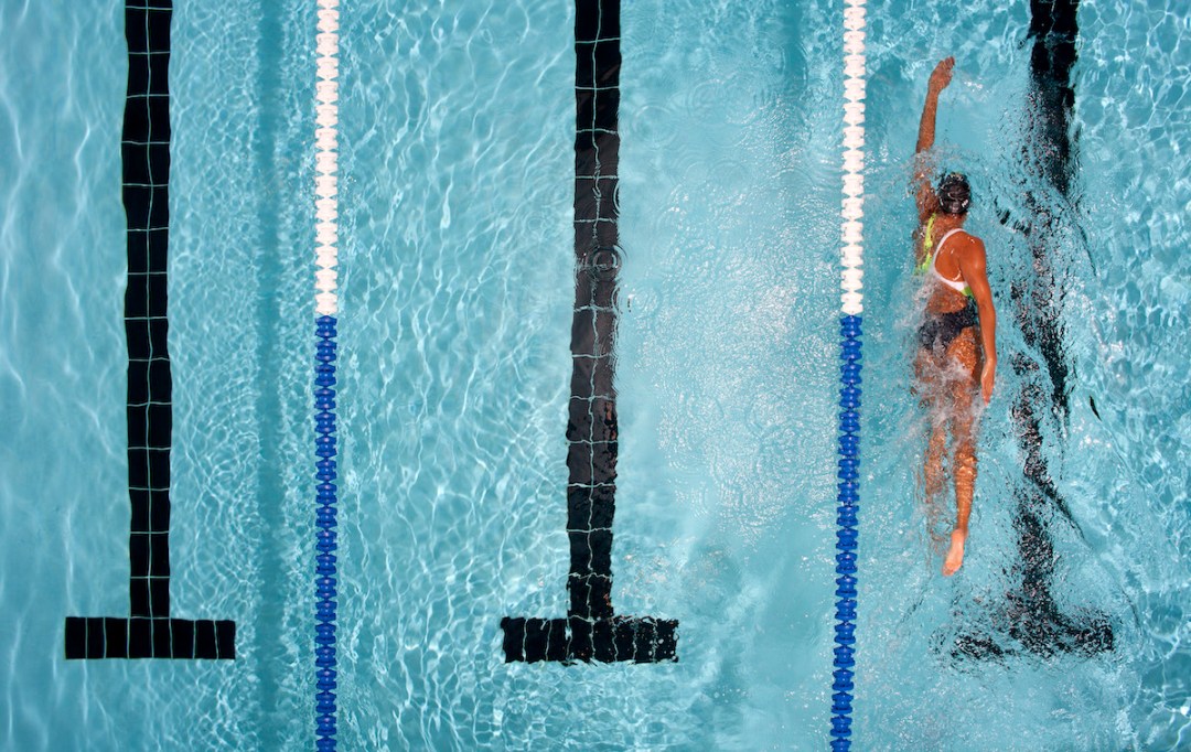 Overhead shot of female swimmer in the far right lane of swimming pool