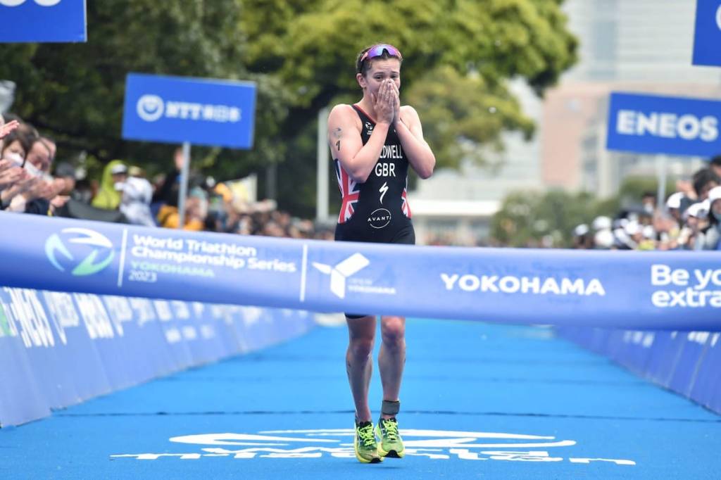 Sophia Coldwell puts her hands over her mouth as she crosses the line to win her first WTCS race in Yokohama, 2023