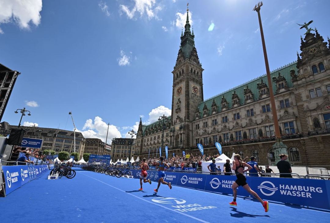 Elite female triathletes run past the town hall during the 2022 Hamburg World Triathlon Series race