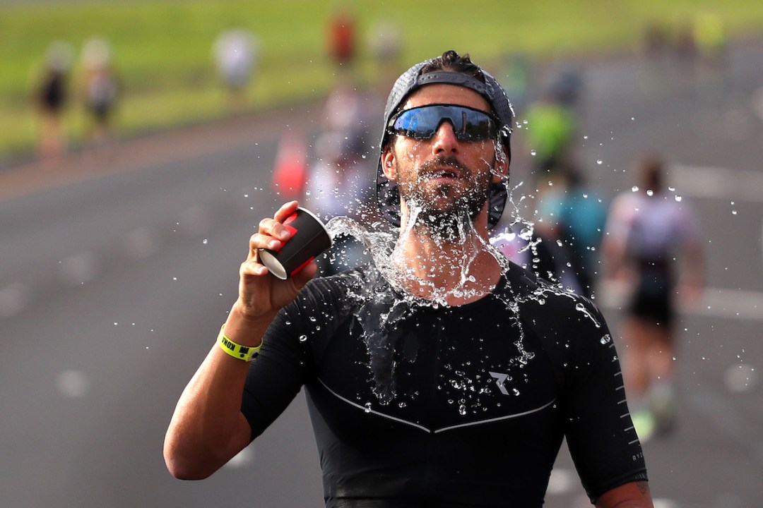 A male triathlete throws water over his face during the 2019 Ironman World Championship, in Kailua Kona, Hawaii