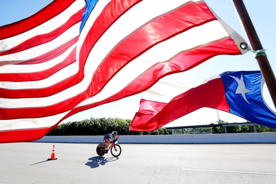 US pro triathlete Jocelyn McCauley cycles under the American and Texas state flags during the 2019 Ironman North American Championship, in Texas