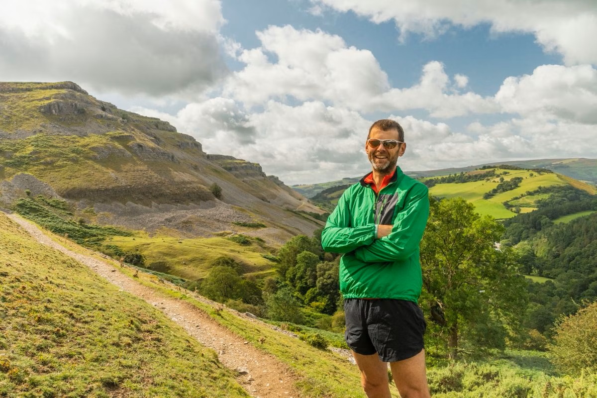 A smiling man on the side of a mountain