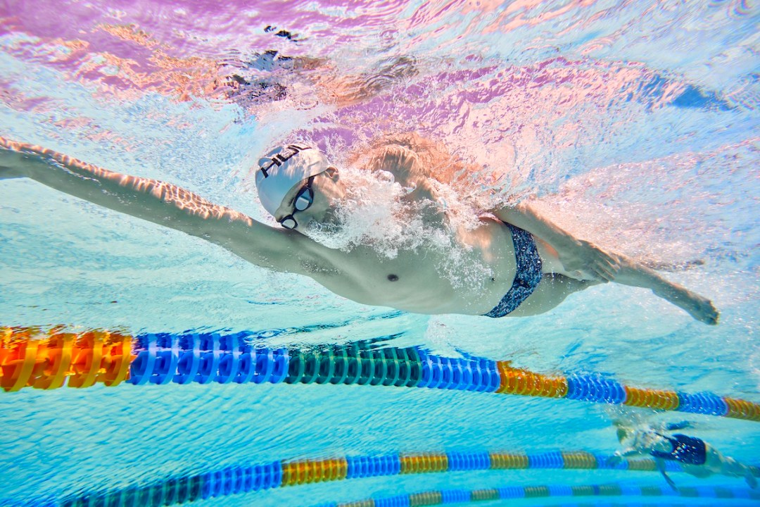 Underwater shot of a male swimmer doing front crawl in a pool lane