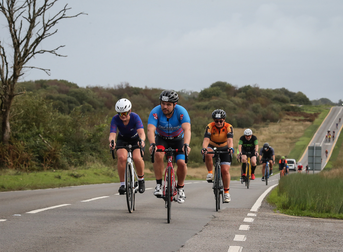 Image of cyclists heading towards the camera on a long street of road at the 2023 Mumbles Triathlon