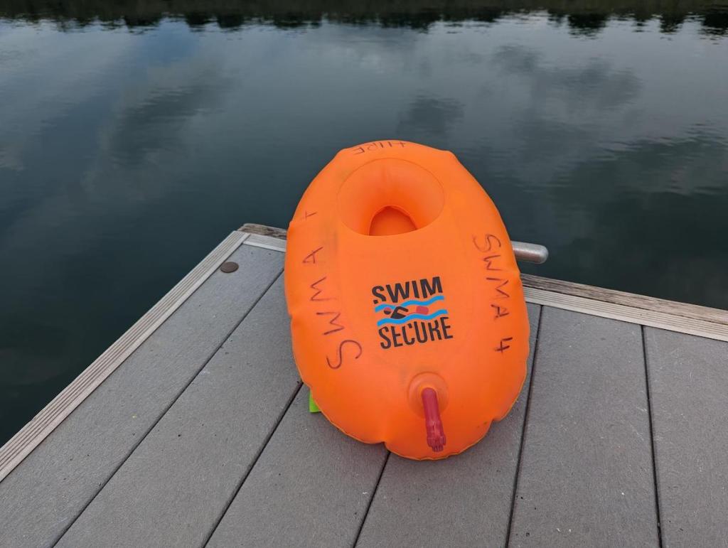 Swim Secure Hydration Float on a jetty by a lake