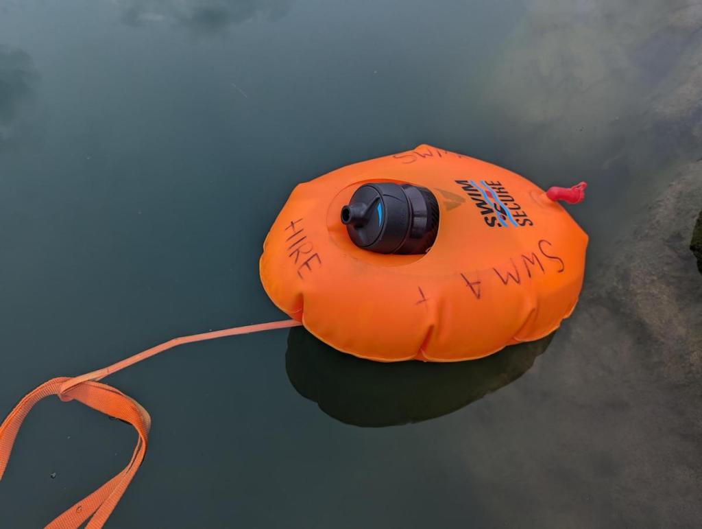 Swim Secure Hydration Float in the water with a bottle inside it