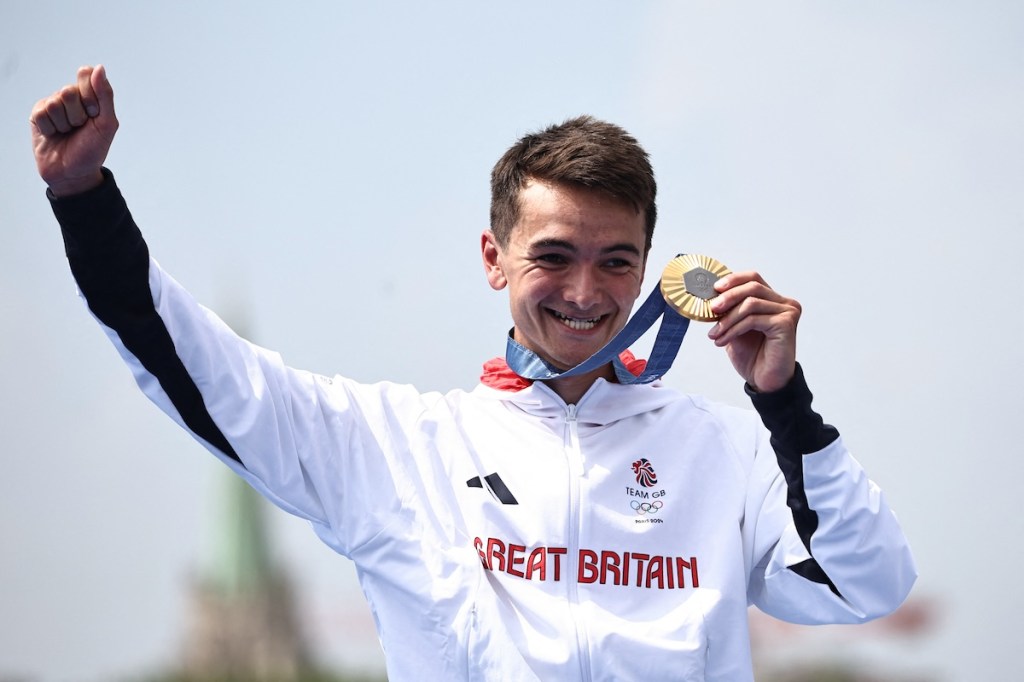 Gold medallist Britain's Alex Yee reacts on the podium during the victory ceremony for the men's individual triathlon at the Paris 2024 Olympic Games in central Paris on July 31, 2024. 