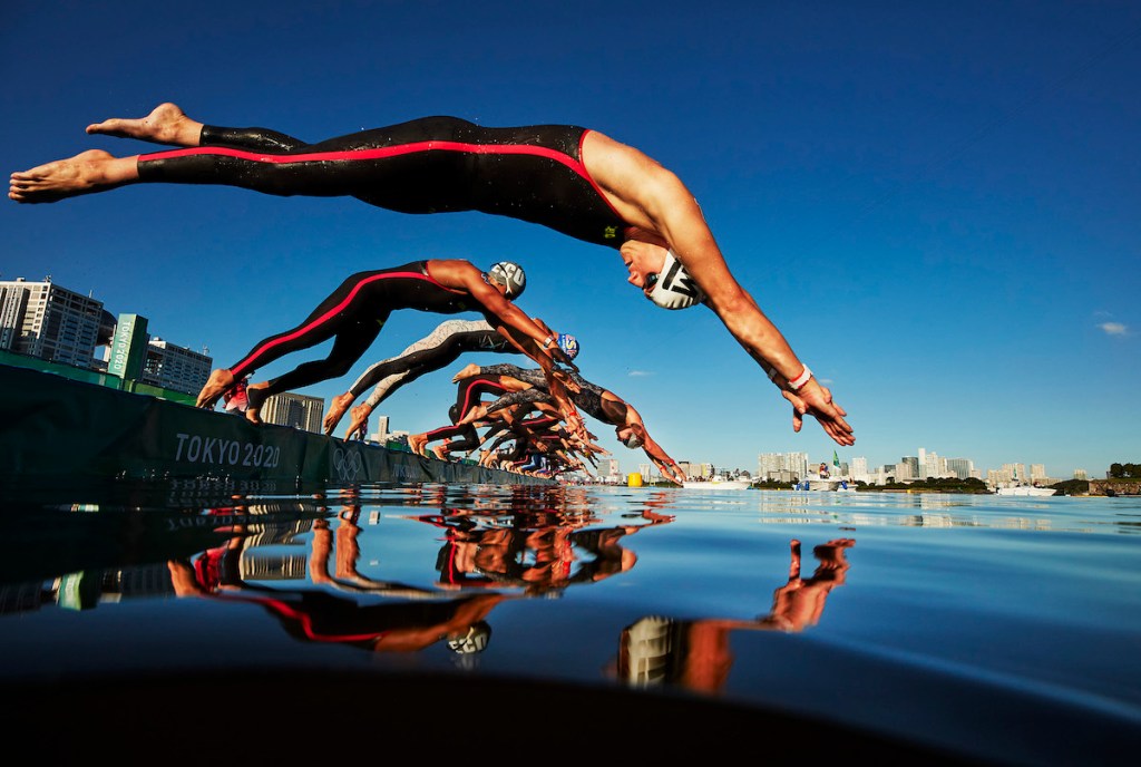 Men dive into the water at the start of the Tokyo 2020 Olympic Games swim