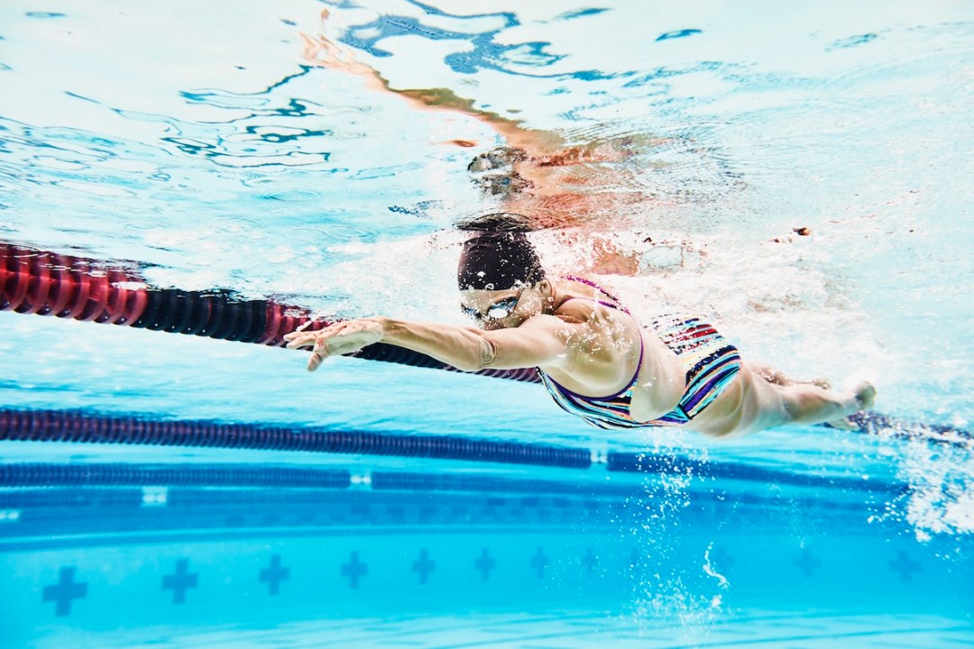 Underwater view of mature female athlete swimming during workout