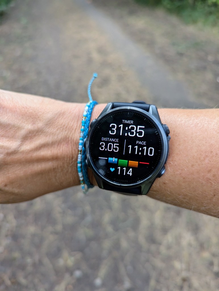 Garmin Fenix 8 on a running screen on female tester's wrist