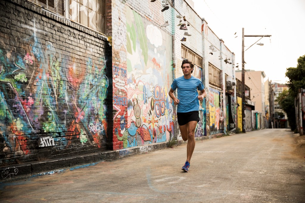 Man doing a tempo run in a city