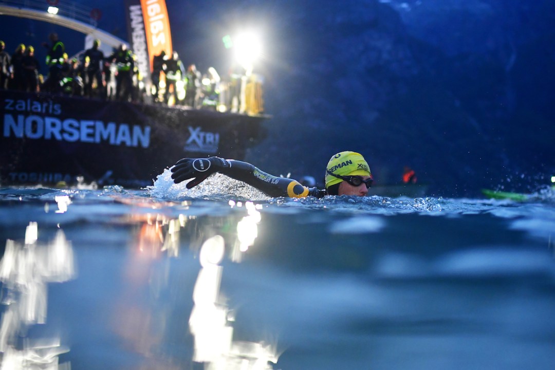 Athlete swimming in front of the ferry at the start of the Zalaris Norseman 2024