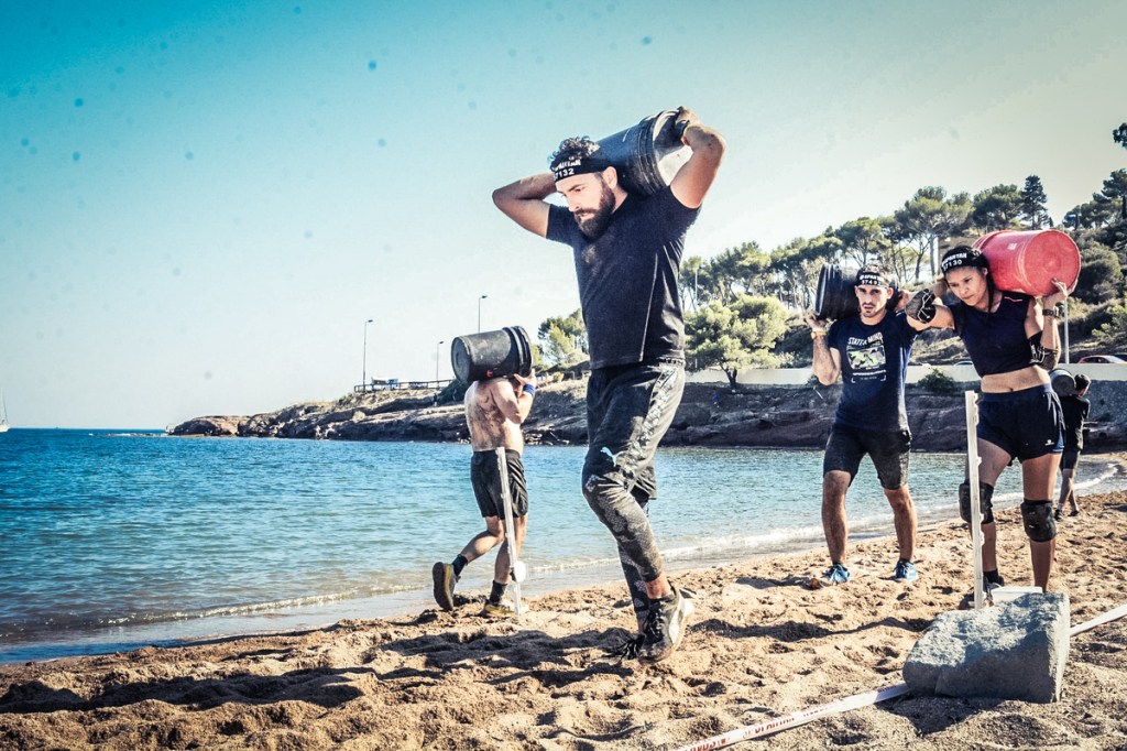 Men and women carrying containers on beach