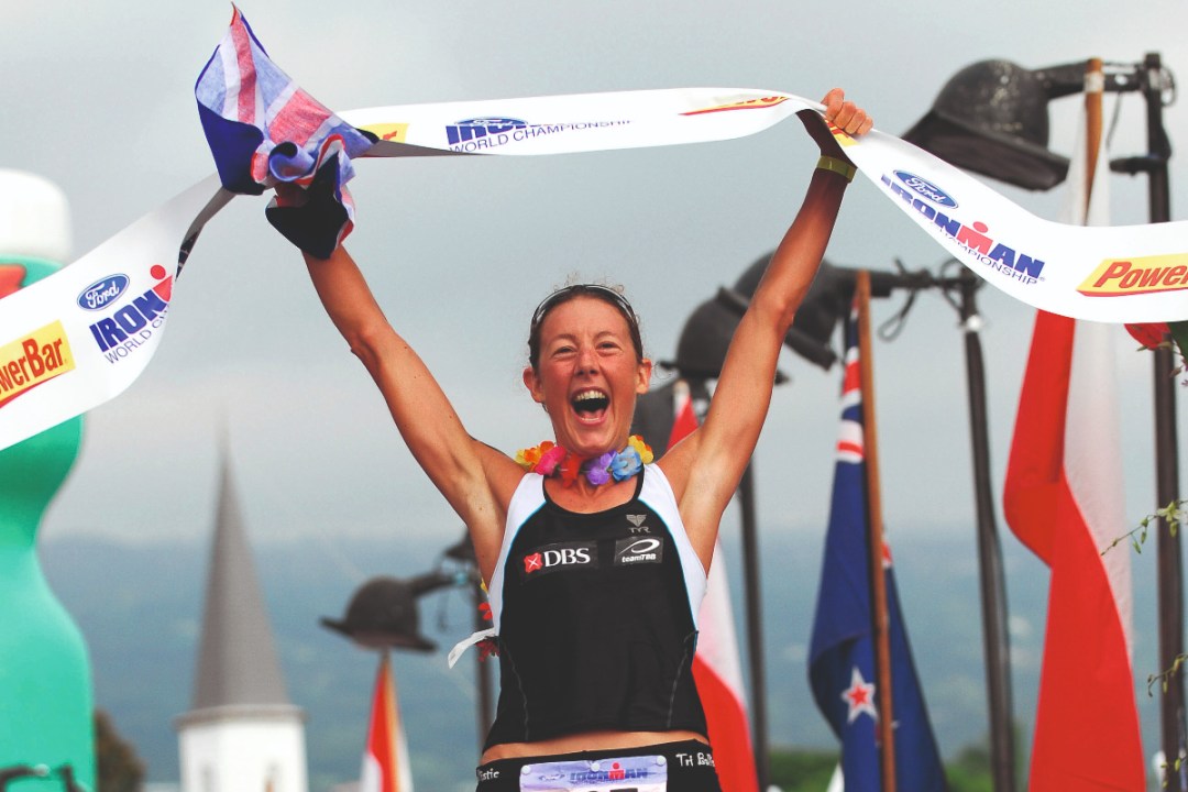 Chrissie Wellington cheers holding finish line above her head