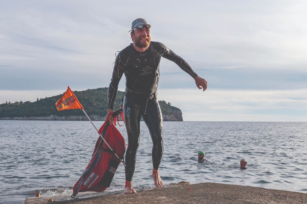 Jonas Deichmann climbs out of the sea during his around-the-world epic equivalent of 120 Iron-distance triathlons in just one year.