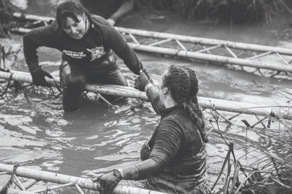 Two women taking part in an obstacle event in water