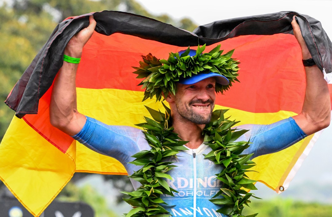 Patrick Lange celebrates with the German flag in Hawaii (Pic credit: Donald Miralle for Ironman)