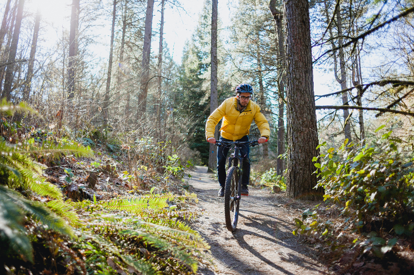 man riding mountain bike wearing yellow jacket