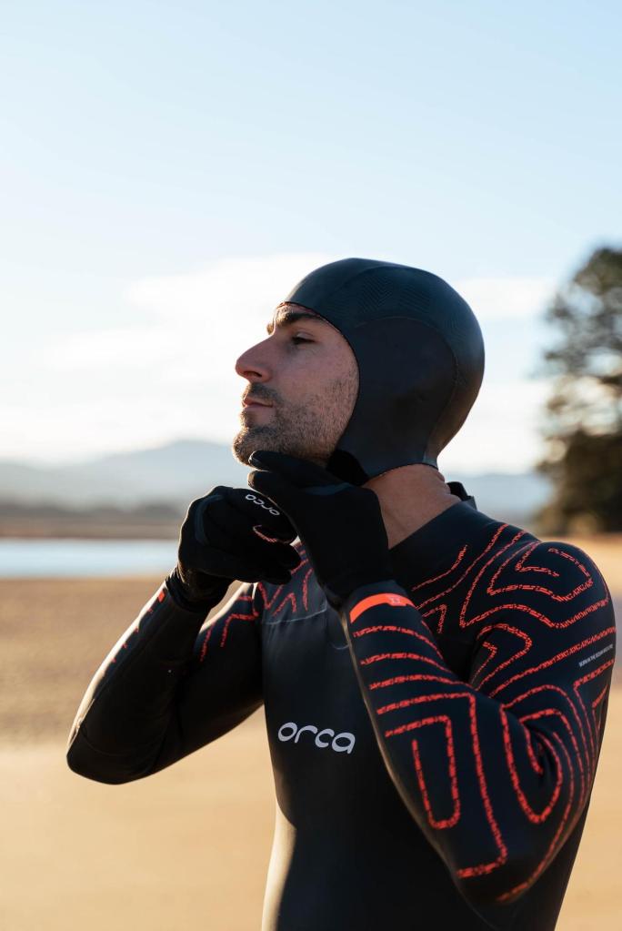 Male swimmer pulling on a neoprene swim cap