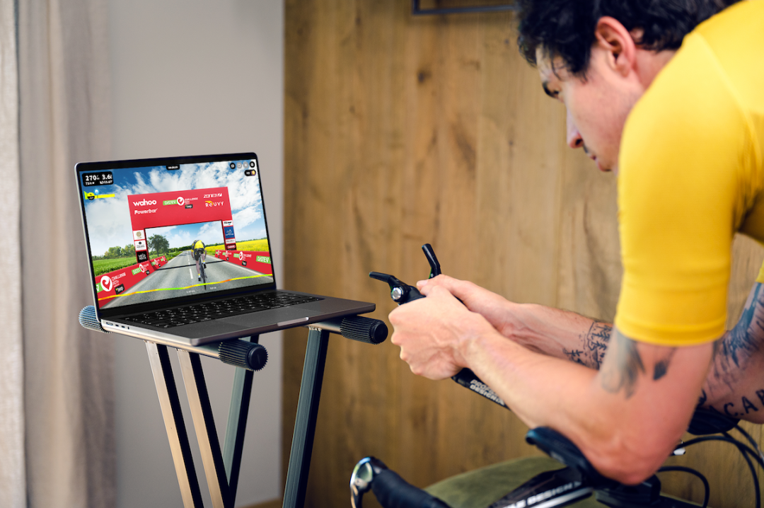 A cyclist on an indoor trainer using the Rouvy platform to train