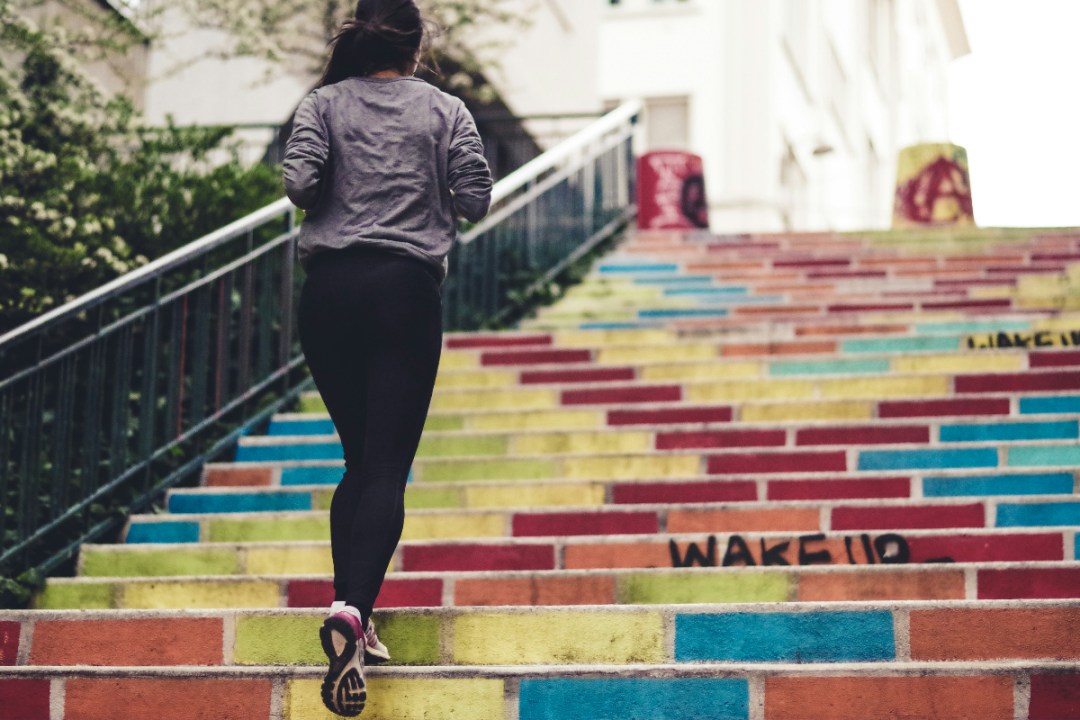 Woman running up colourful steps